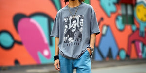 Person in oversized graphic T-shirt with urban backdrop.