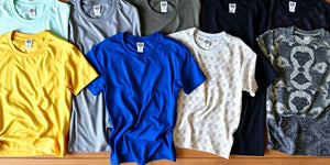 Various 4XL t-shirts displayed on a wooden surface.