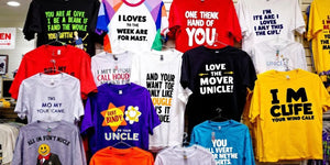 Colourful funny T-shirts on display for gift shopping.