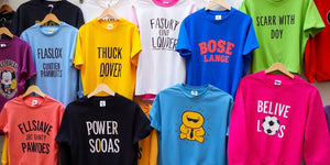 Colourful funny t-shirts and jumpers displayed together.