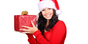 person holding a beautifully wrapped gift in a festive setting